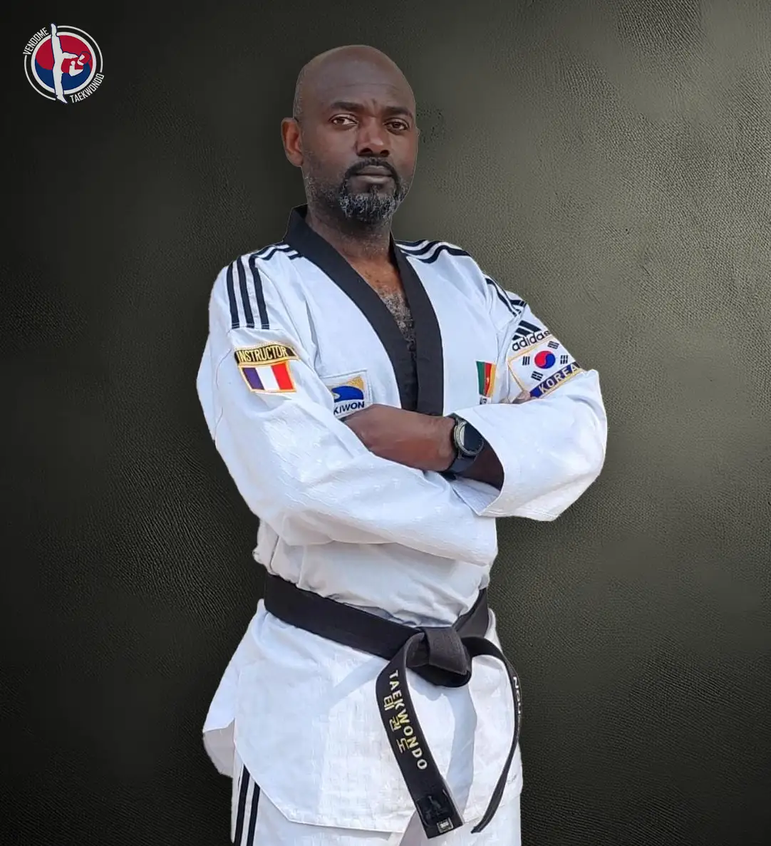 Portait de Guy, vêtu du dobok blanc à col noir, tenue traditionnelle portée par les pratiquants gradés de Taekwondo